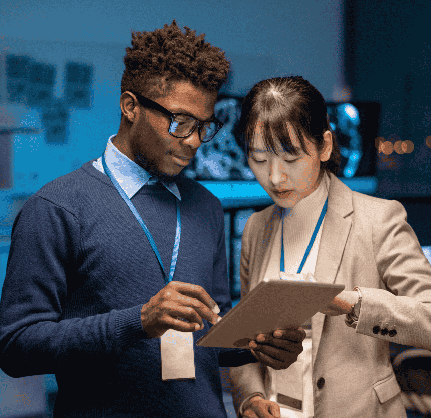 two people standing over a tablet and working together
